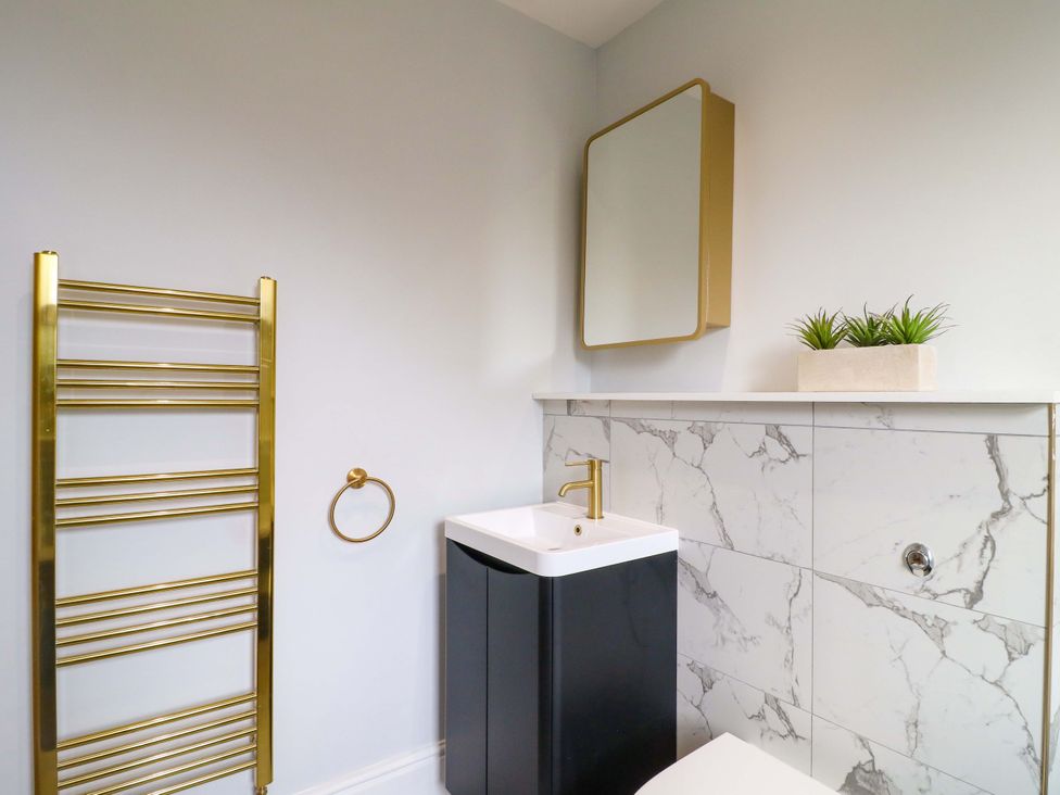 A bathroom with sink and towel radiator at High Peaks Villa in Buxton