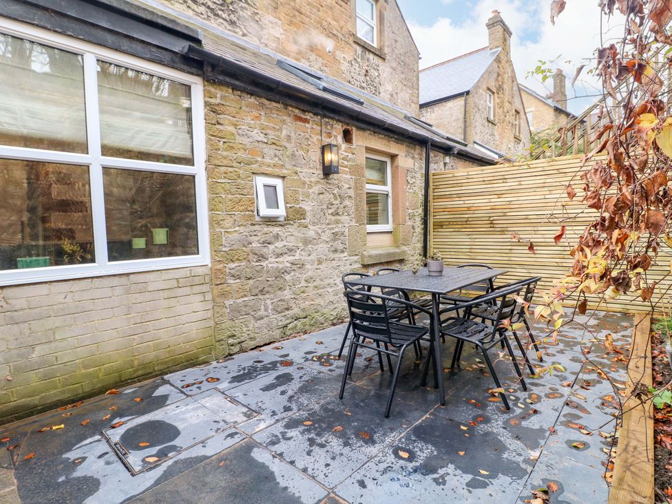 An outdoor patio with a table and chairs at High Peaks Villa in Buxton