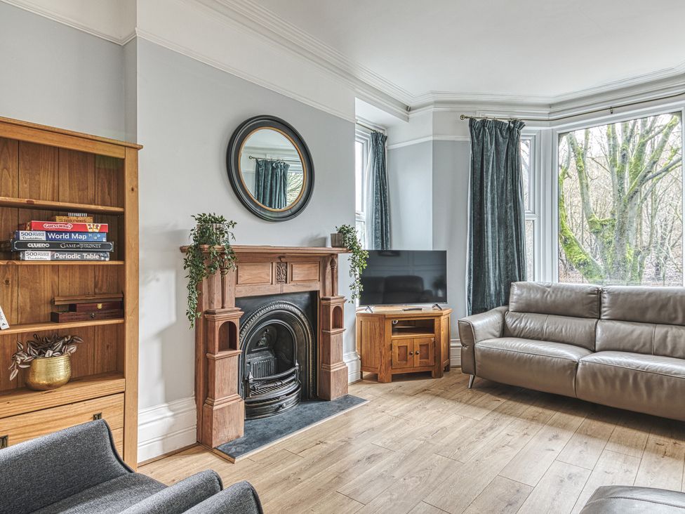 A living room with a fireplace and television at High Peaks Villa in Buxton