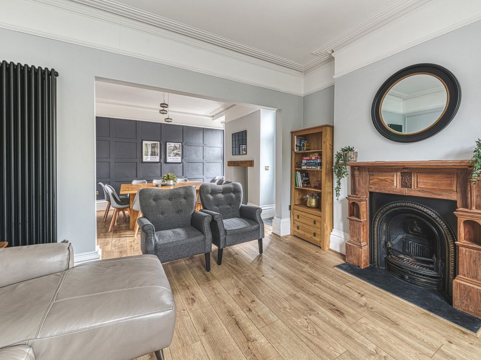 A living room with a fireplace and bookshelf at High Peaks Villa in Buxton