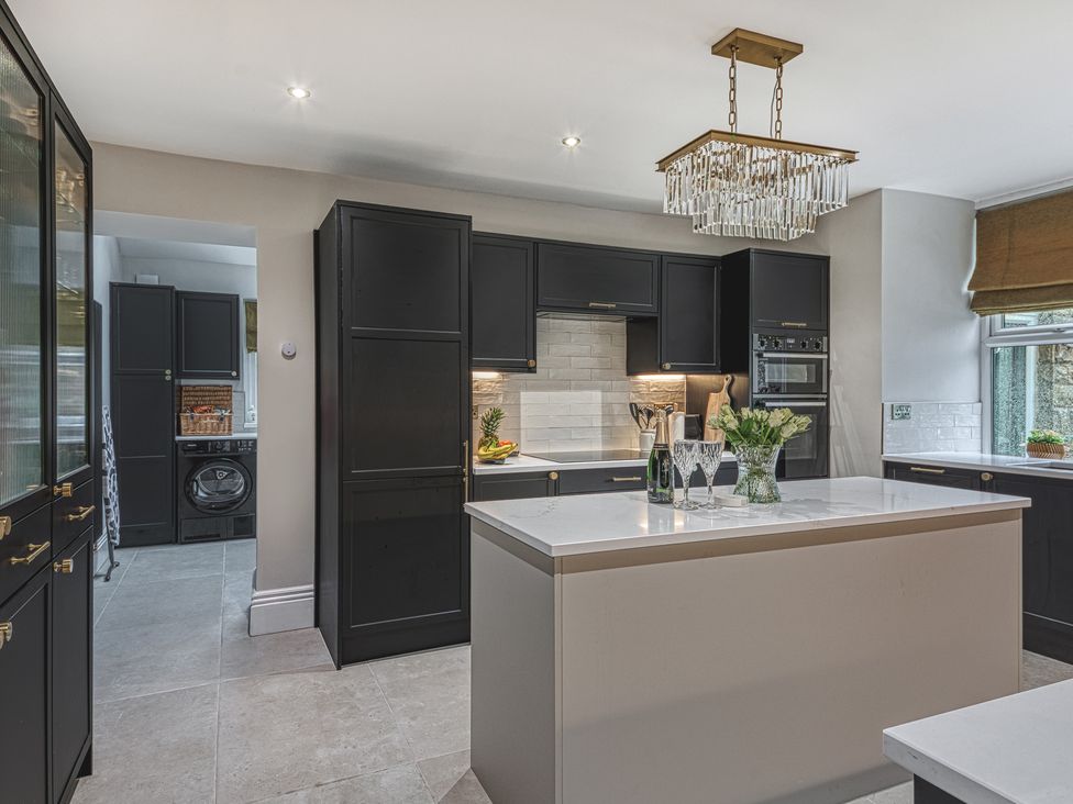 A kitchen with an island and cabinets at High Peaks Villa in Buxton