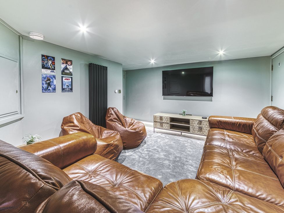 A snug with a sectional sofa and television at High Peaks Villa in Buxton