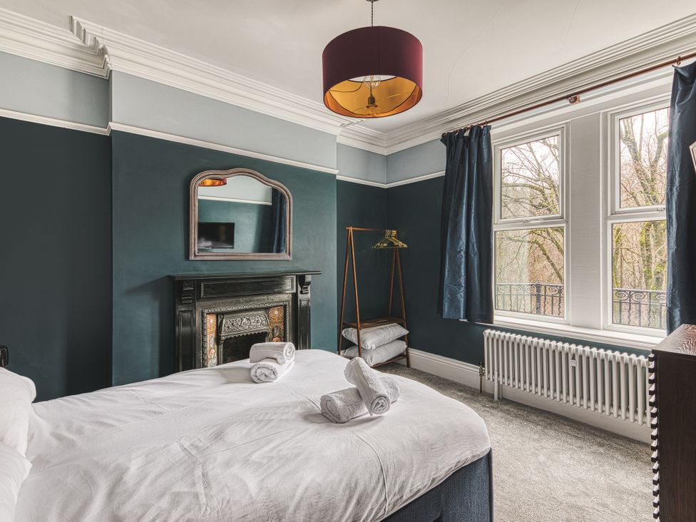 A bedroom with a bed and a fireplace at High Peaks Villa in Buxton