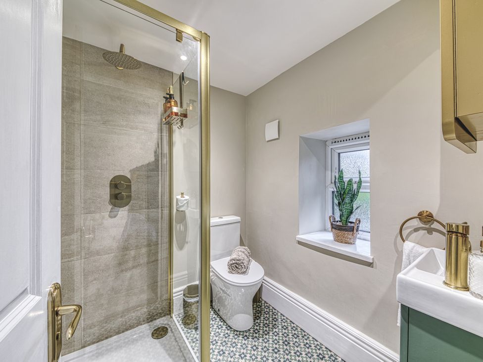 A bathroom with a shower, toilet, and sink at High Peaks Villa in Buxton