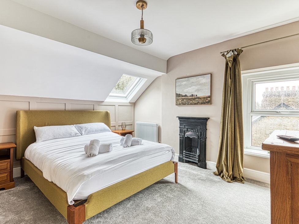 A bedroom with a bed, bedside table, and window at High Peaks Villa in Buxton