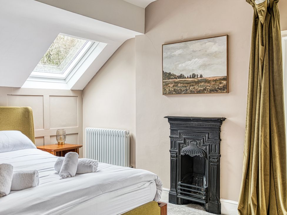 A bedroom with a bed and fireplace at High Peaks Villa in Buxton