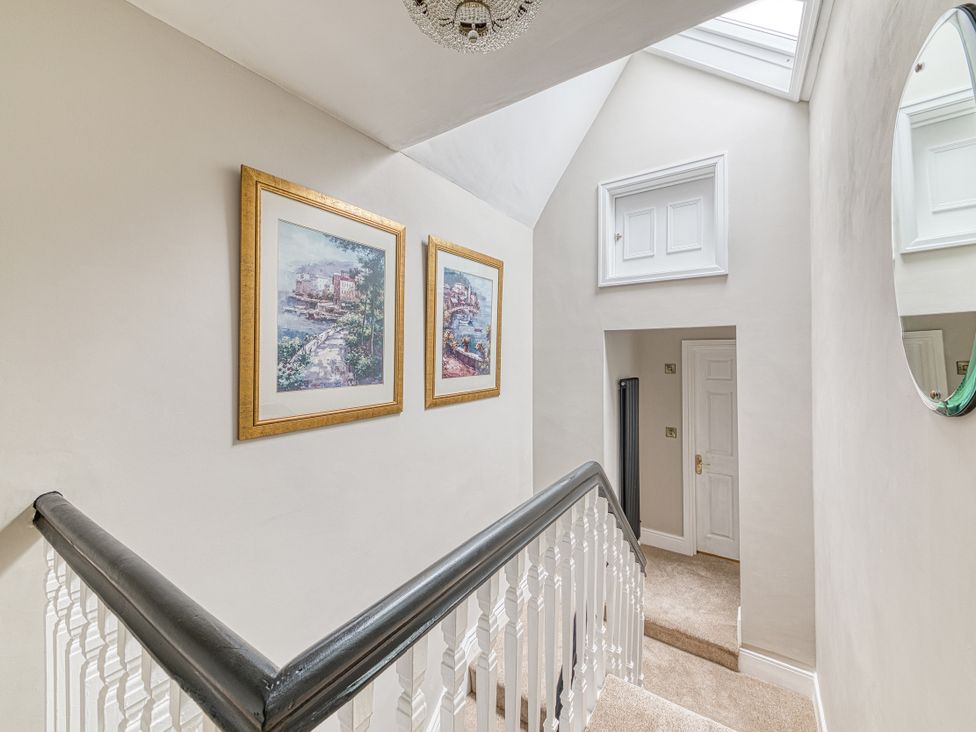 A staircase with paintings on the wall at High Peaks Villa in Buxton