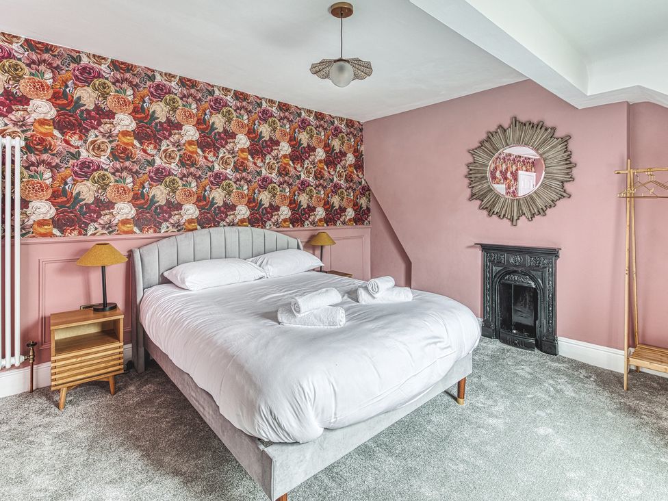 A bedroom with a bed and decorative wallpaper at High Peaks Villa Buxton