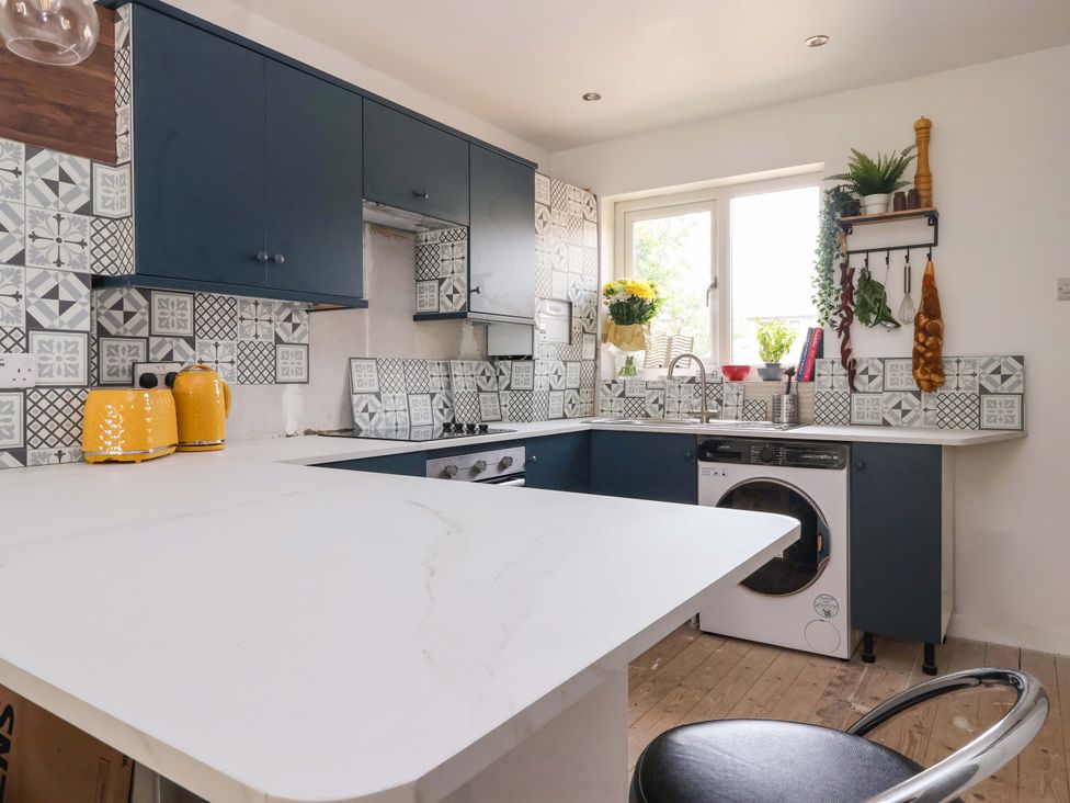 A kitchen with cabinets and a washing machine at 8 Wharfedale Mews Otley