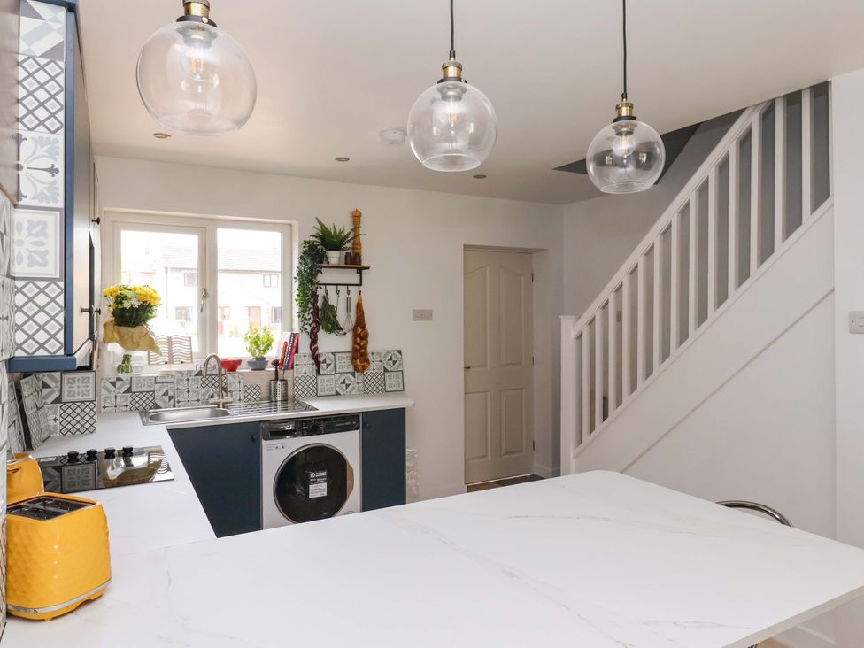 A kitchen with a sink and stove at 8 Wharfedale Mews in Otley