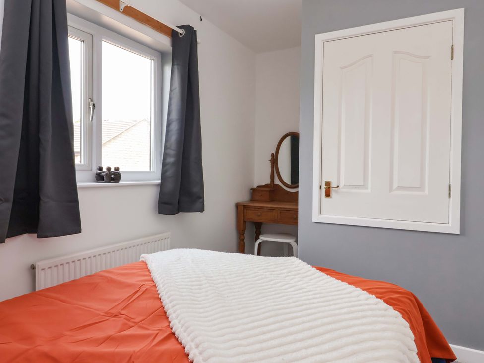 A bedroom with a bed and a dressing table at 8 Wharfedale Mews in Otley