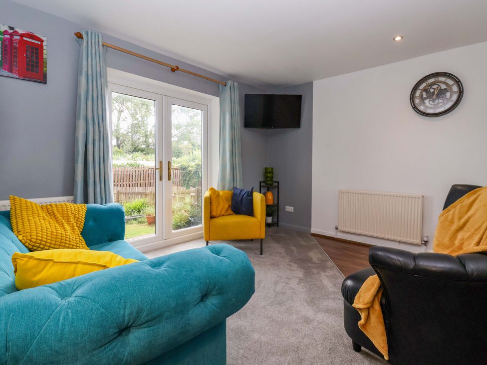 A living room with a sofa and armchair at 8 Wharfedale Mews in Otley
