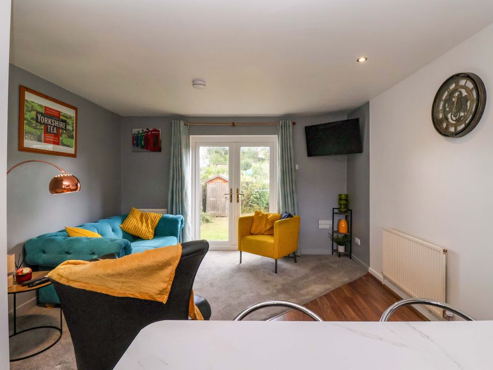 A living room with a sofa and armchair at 8 Wharfedale Mews in Otley