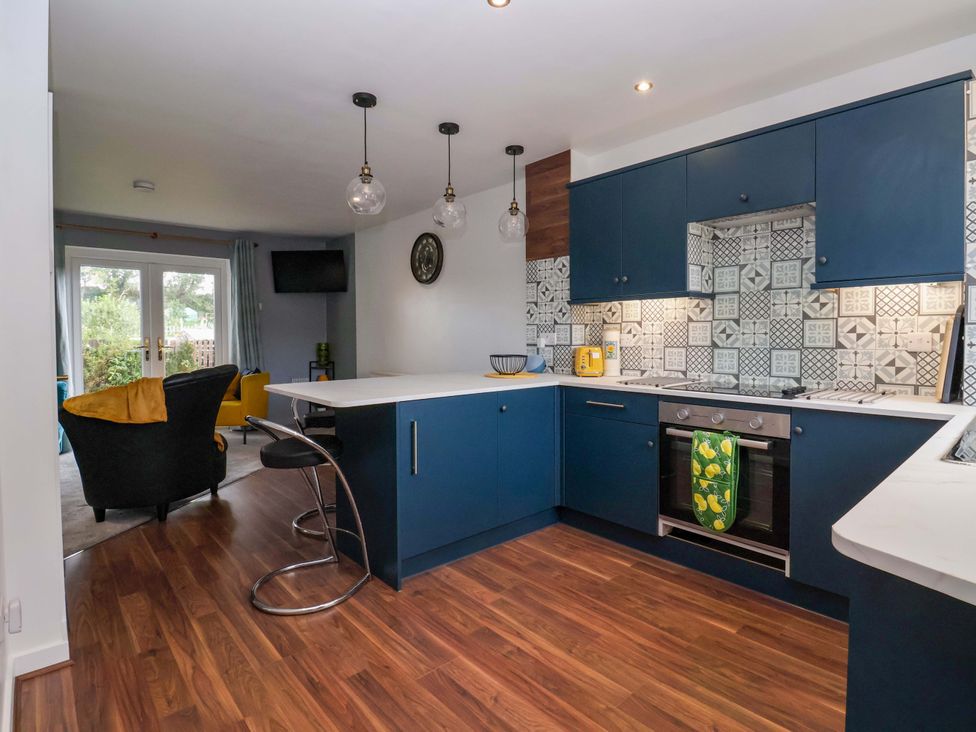 A kitchen with blue cabinets and an island at 8 Wharfedale Mews in Otley