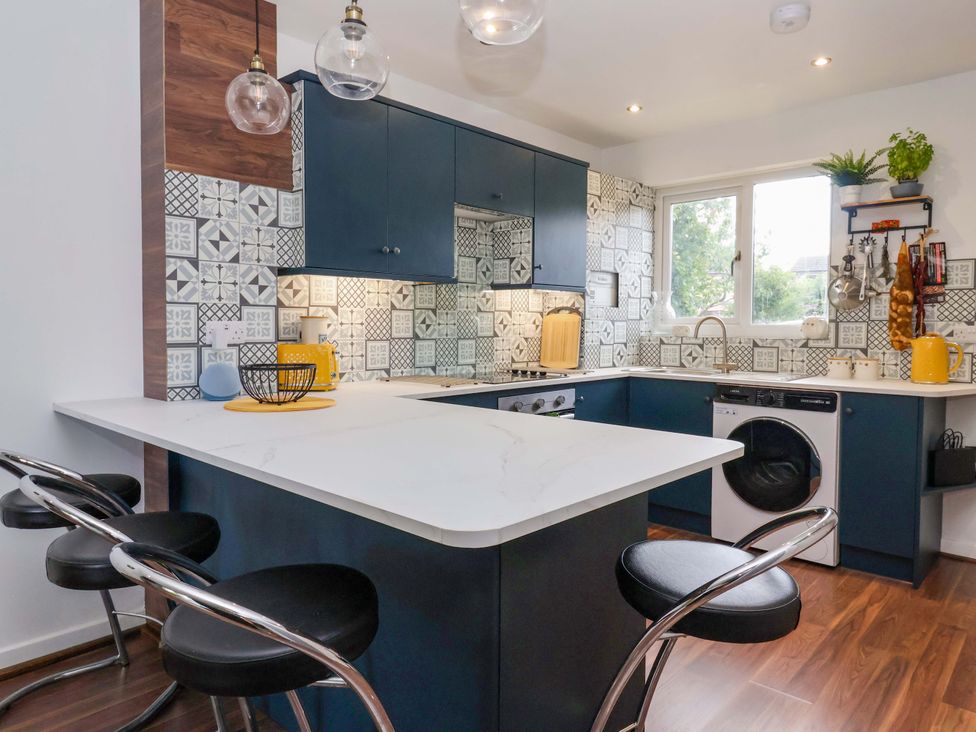 A kitchen with cabinets, washing machine and countertop at 8 Wharfedale Mews in Otley