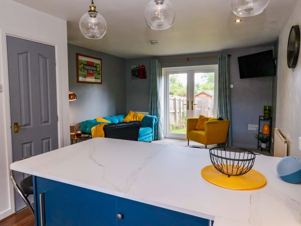 A living room with a sofa and armchair at 8 Wharfedale Mews in Otley