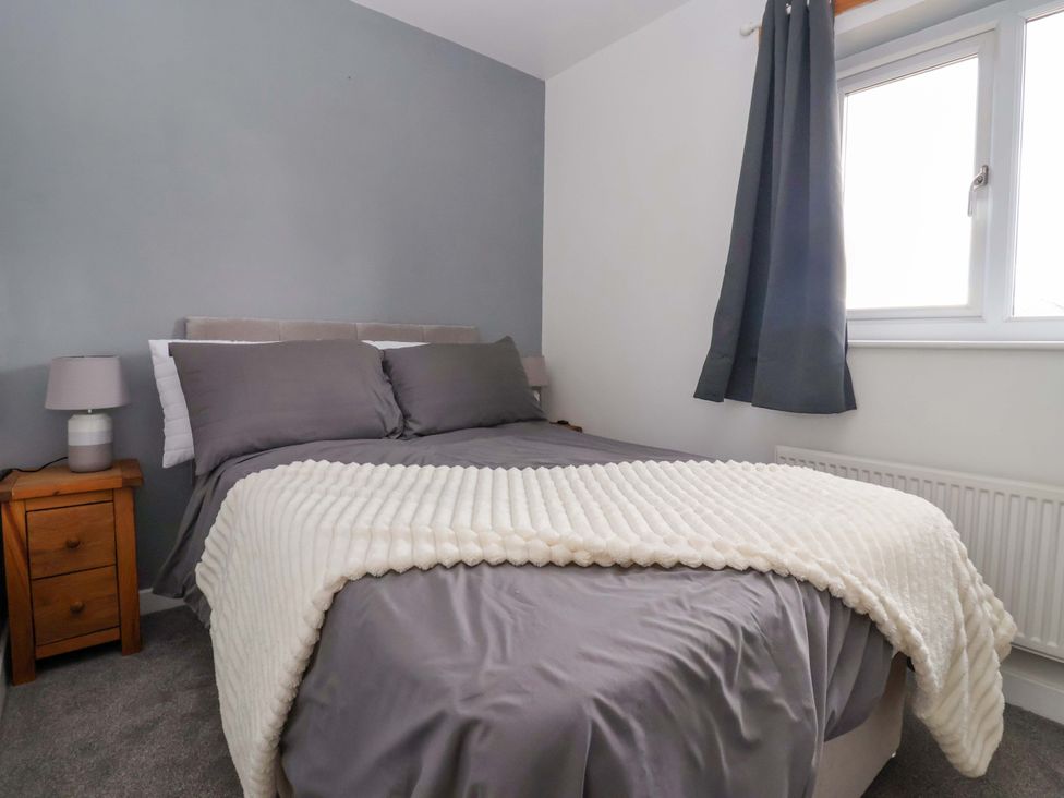 A bedroom with a bed and nightstand at 8 Wharfedale Mews in Otley