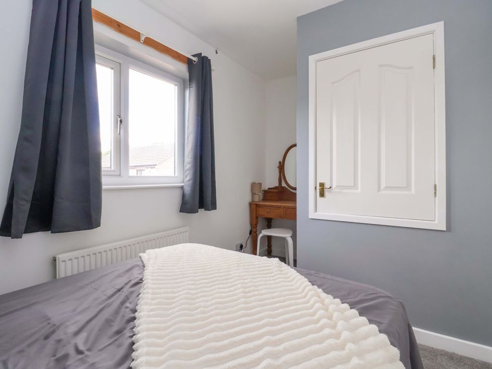 A bedroom with a bed and window at 8 Wharfedale Mews in Otley