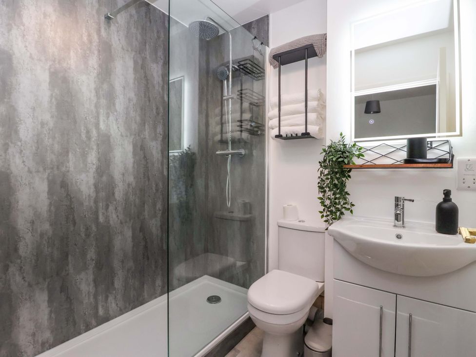 A bathroom with a shower, toilet, and sink at 8 Wharfedale Mews in Otley