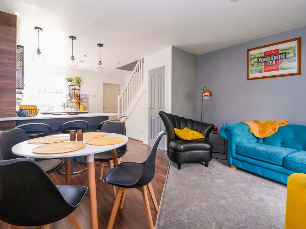 A living room with a table and chairs at 8 Wharfedale Mews in Otley