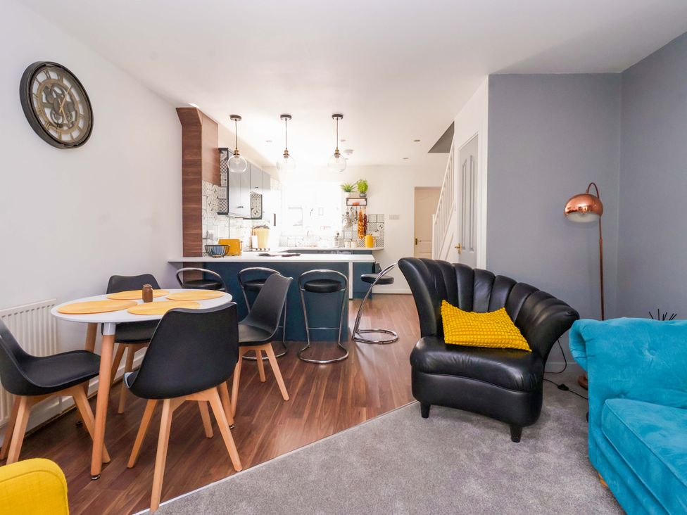 A living room with a dining area and kitchen at 8 Wharfedale Mews in Otley