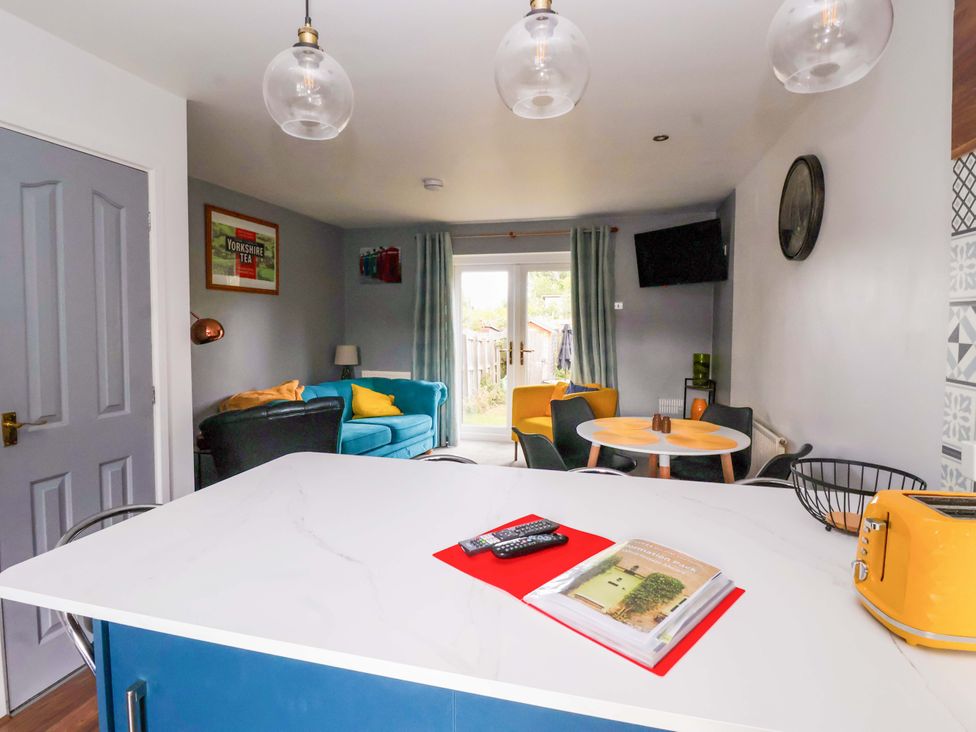 A kitchen with dining area and television at 8 Wharfedale Mews in Otley
