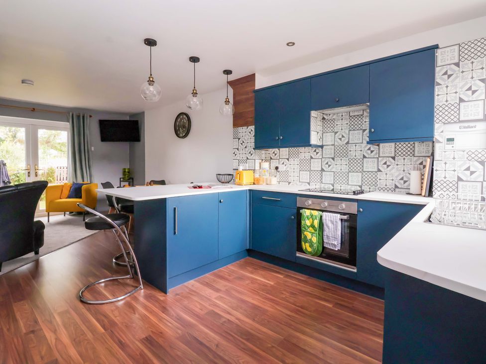 A kitchen with stove, cabinets, and kettle at 8 Wharfedale Mews in Otley
