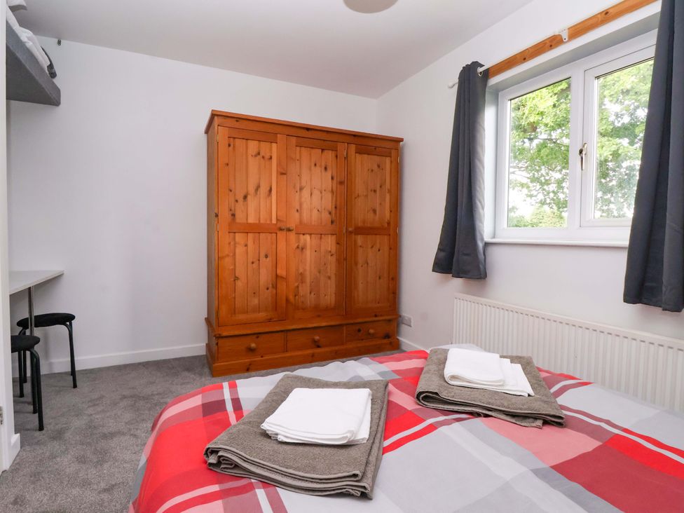 A bedroom with a wardrobe and bed at 8 Wharfedale Mews in Otley