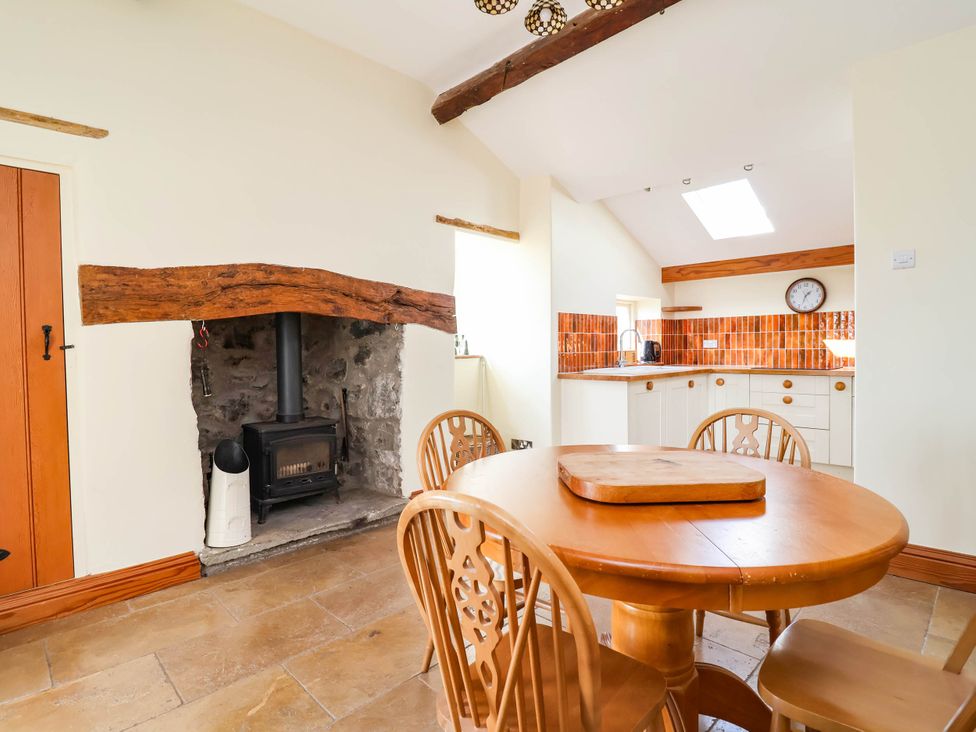 A dining room with a table and chairs at Ael Y Bryn Dyserth