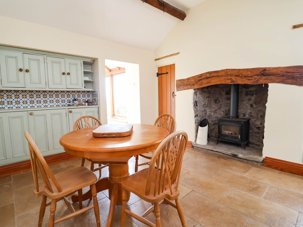 A dining room with a table and chairs at Ael Y Bryn Dyserth
