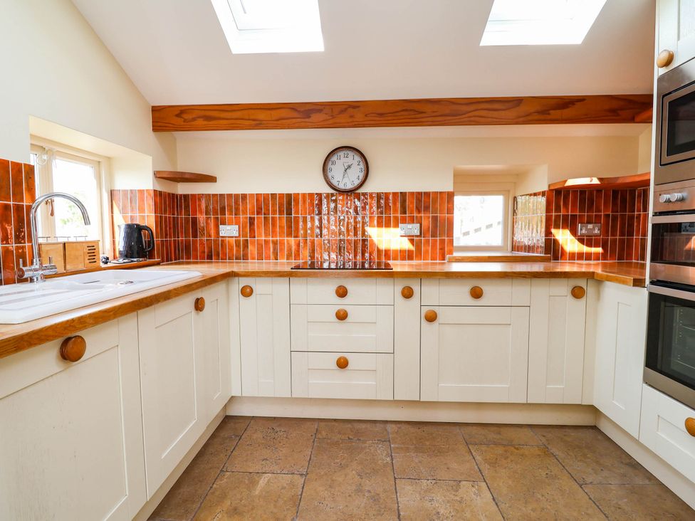 A kitchen with cabinets, sink, and kettle at Ael Y Bryn in Dyserth