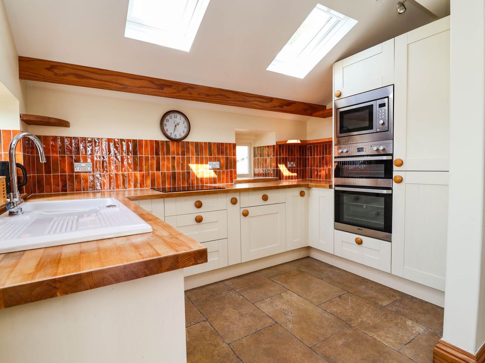 A kitchen with a sink and oven at Ael Y Bryn in Dyserth