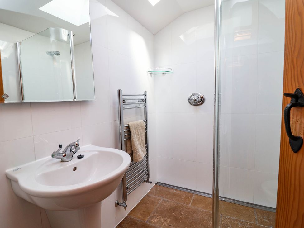 A bathroom with a wash basin and shower at Ael Y Bryn in Dyserth