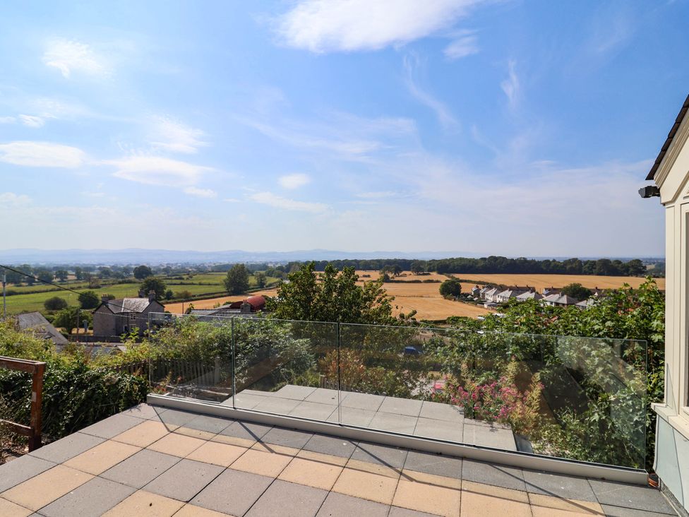 An outdoor view showing a patio and surrounding fields at Ael Y Bryn Dyserth