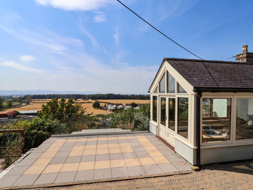 A conservatory with glass windows overlooking the landscape at Ael Y Bryn Dyserth