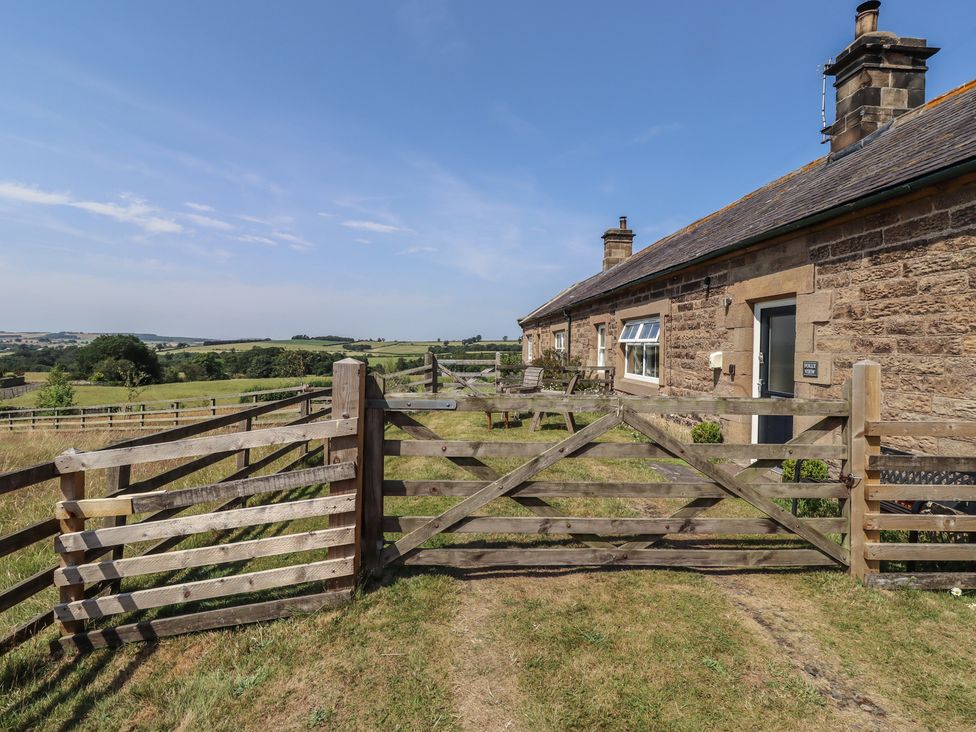 A wooden gate leading to a house in a field at Folly View in Eglingham