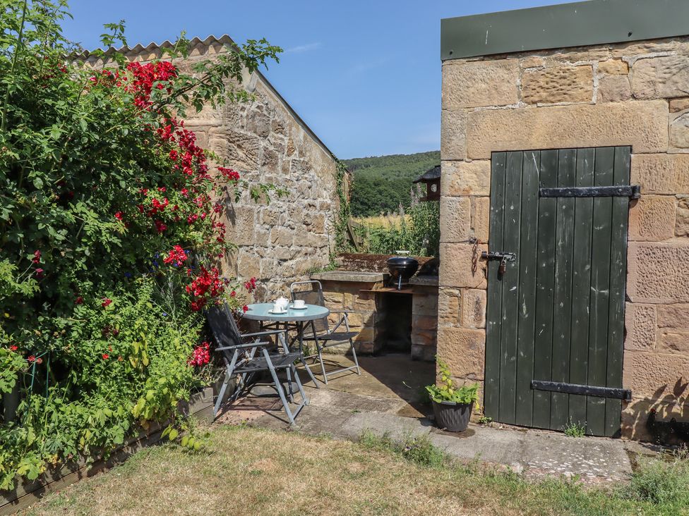 A garden with a table and chairs at Folly View in Eglingham