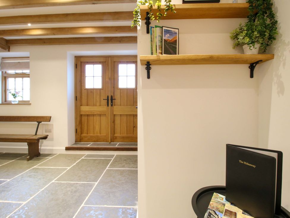 A hallway with a bench and shelves at The Hideaway in Bishop's Castle
