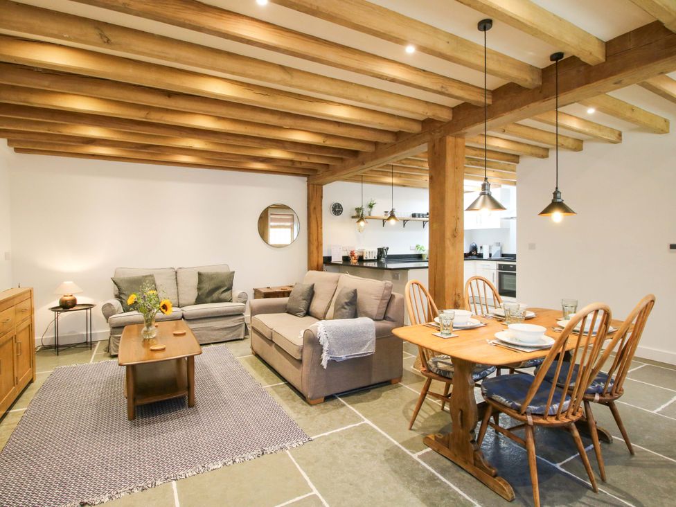 A living room with a sofa and dining area at The Hideaway in Bishop's Castle