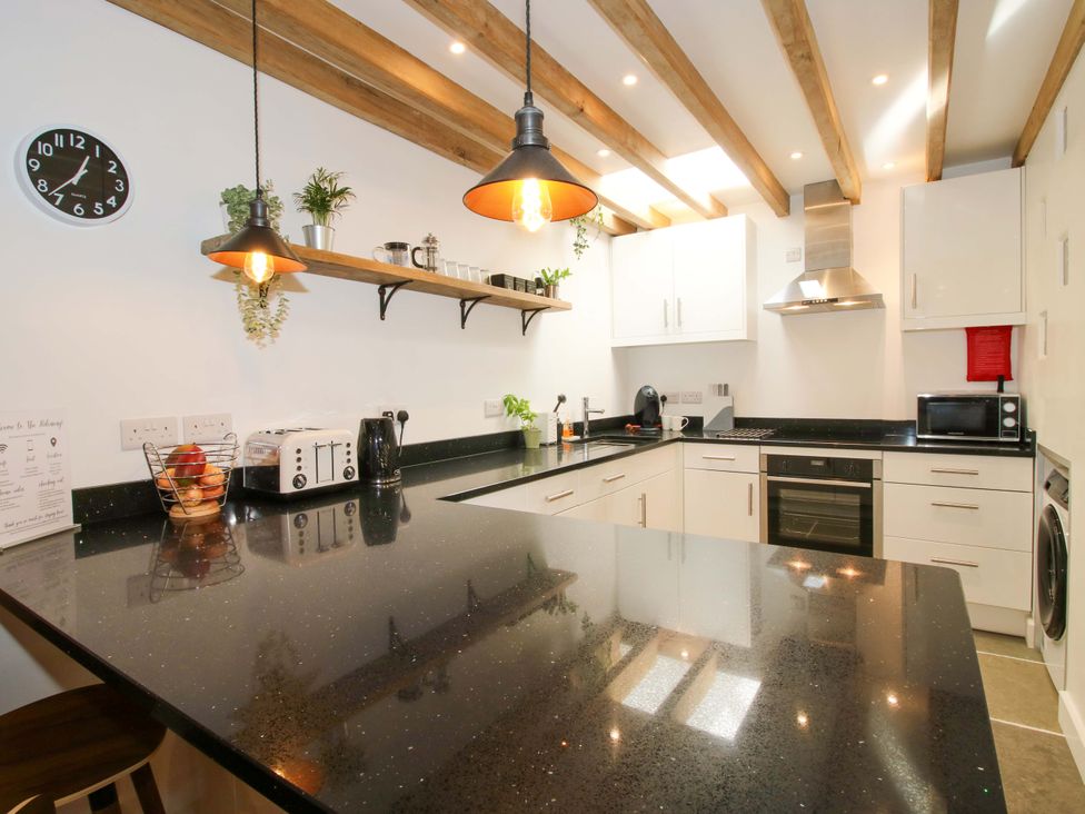 A kitchen with an island and appliances at The Hideaway in Bishop's Castle