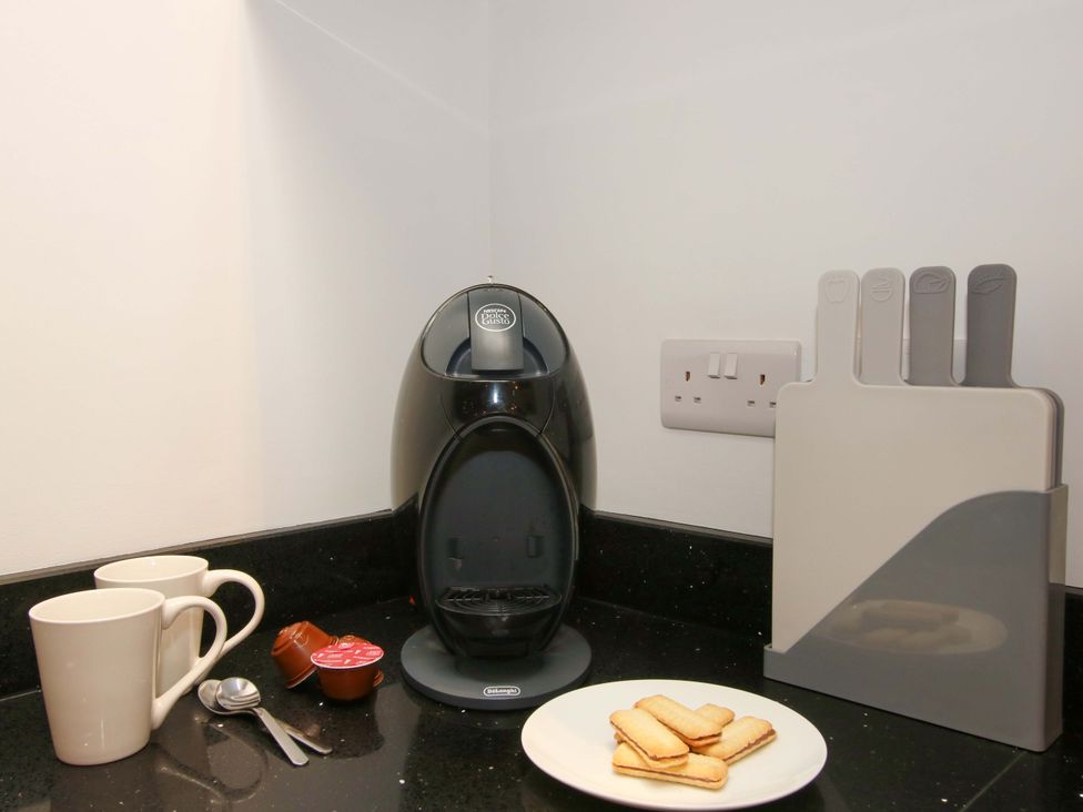 A coffee machine with mugs and cookies at The Hideaway in Bishop's Castle