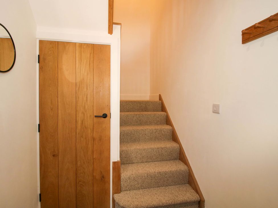 A staircase and wooden door in a hallway at The Hideaway in Bishop's Castle