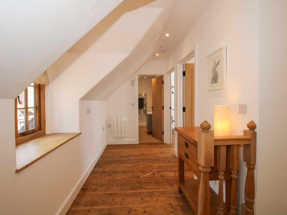 A hallway with a wooden console table and lamp at The Hideaway in Bishop's Castle