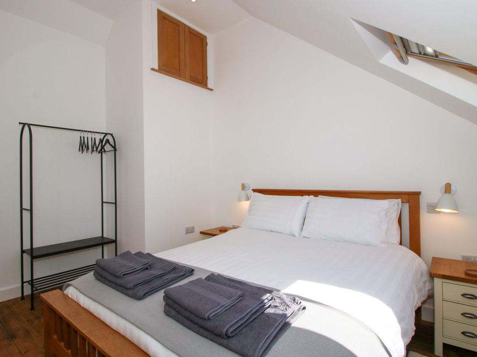 A bedroom with a bed and hanging rack at The Hideaway in Bishop's Castle