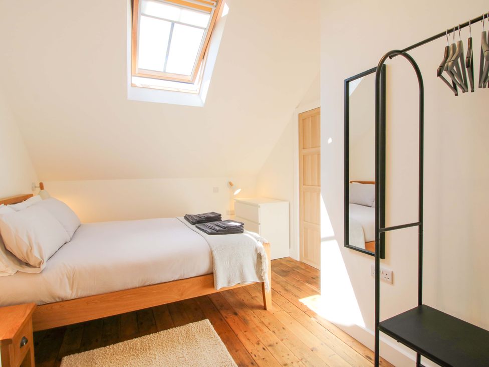 A bedroom with a bed and mirror at The Hideaway in Bishop's Castle