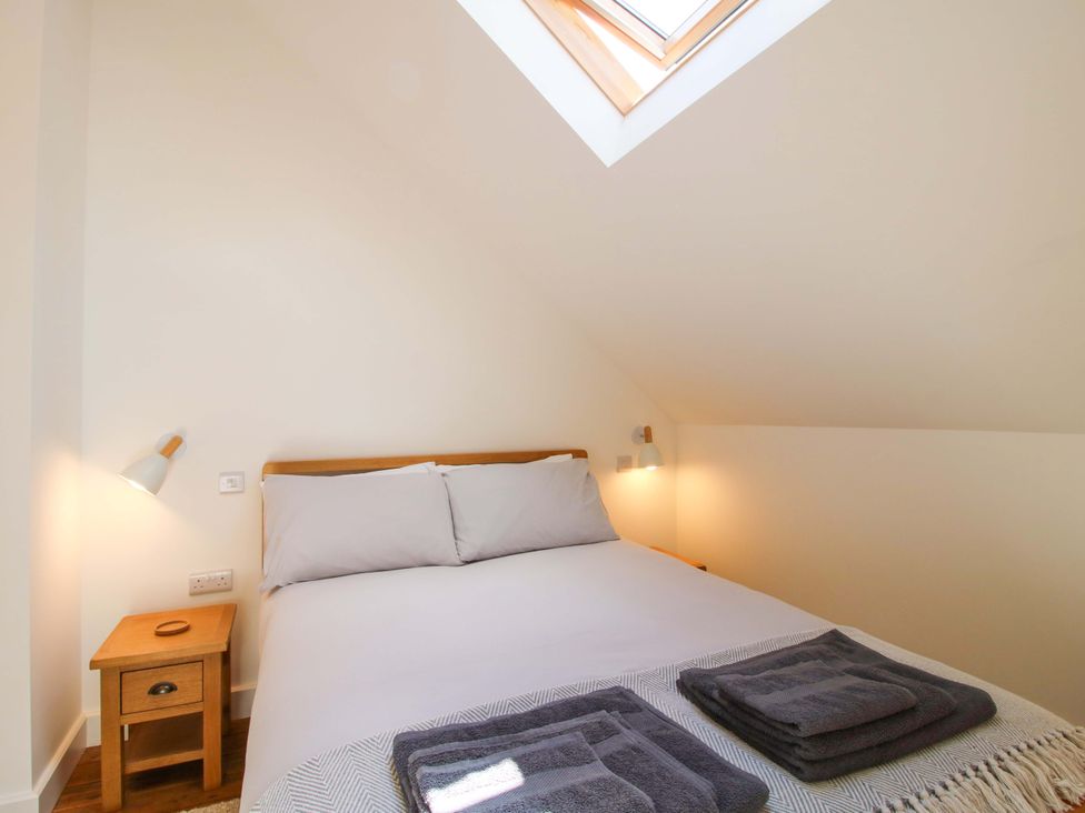 A bedroom with a bed and bedside table at The Hideaway in Bishop's Castle
