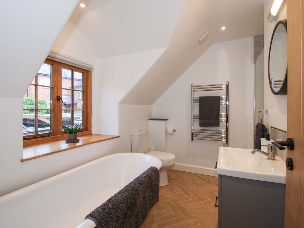 A bathroom with a bathtub, sink, and window at The Hideaway in Bishop's Castle