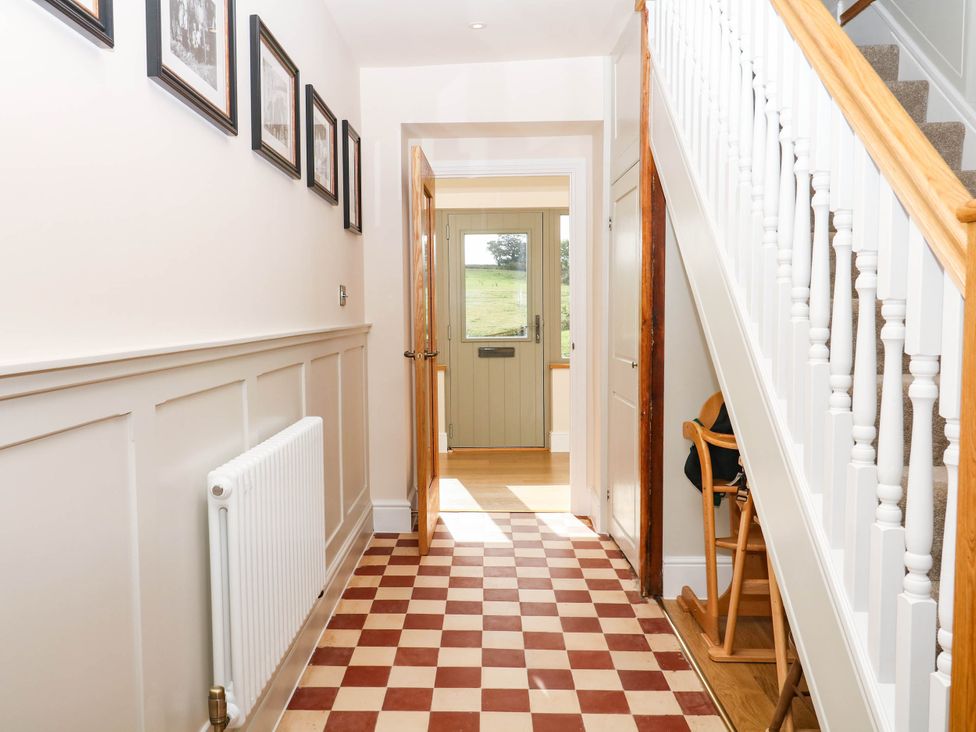 A hallway with a staircase and door at Higher Weekaborough Farm near Coombe Fishacre Ipplepen