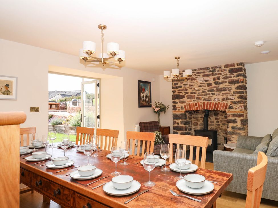 A dining room with a wooden table and chairs at Higher Weekaborough Farm in Coombe Fishacre near Ipplepen