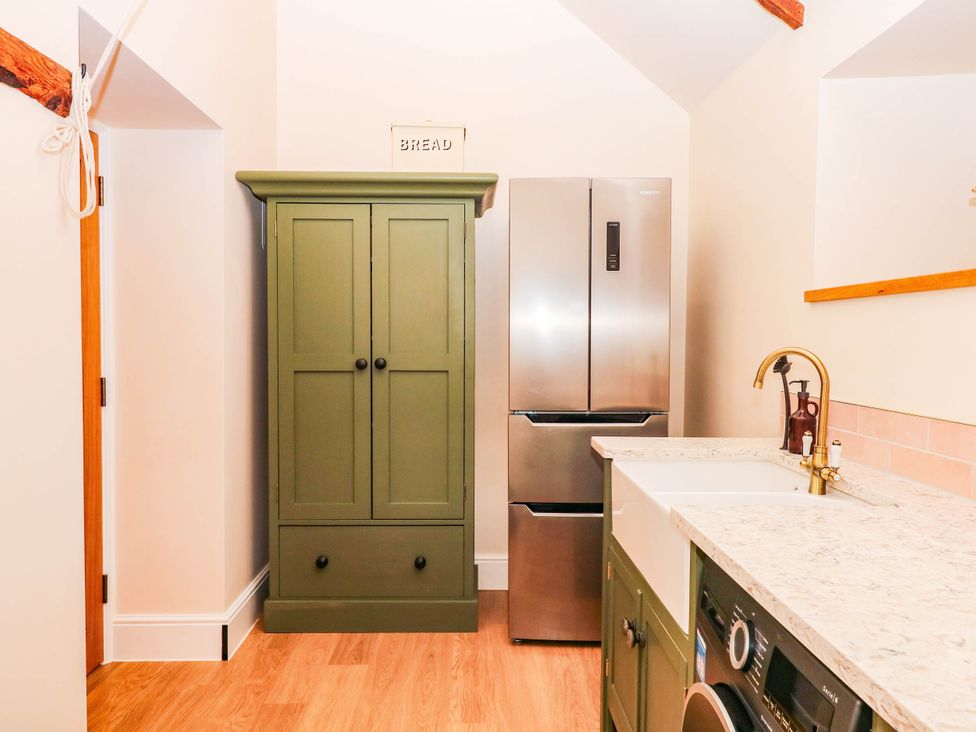 A kitchen with a refrigerator and green cabinet at Higher Weekaborough Farm near Coombe Fishacre Ipplepen